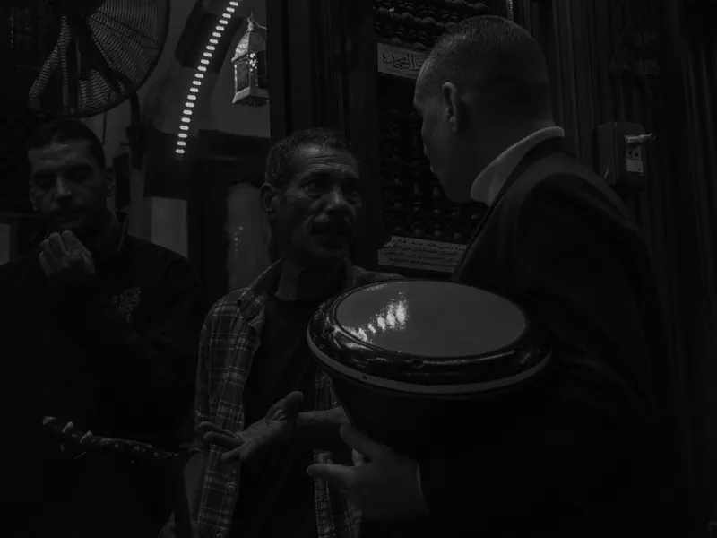 A group gathered close together in a dim room, black and white