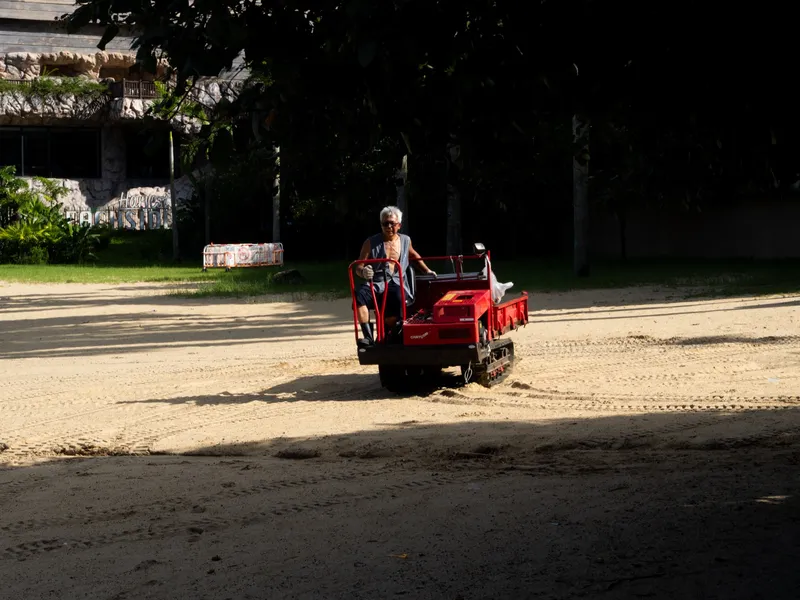A red quad bike on an empty road with dense green either side