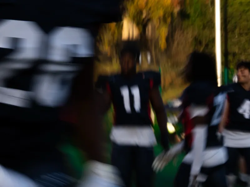 Players moving across the field, jersey numbers smeared with motion