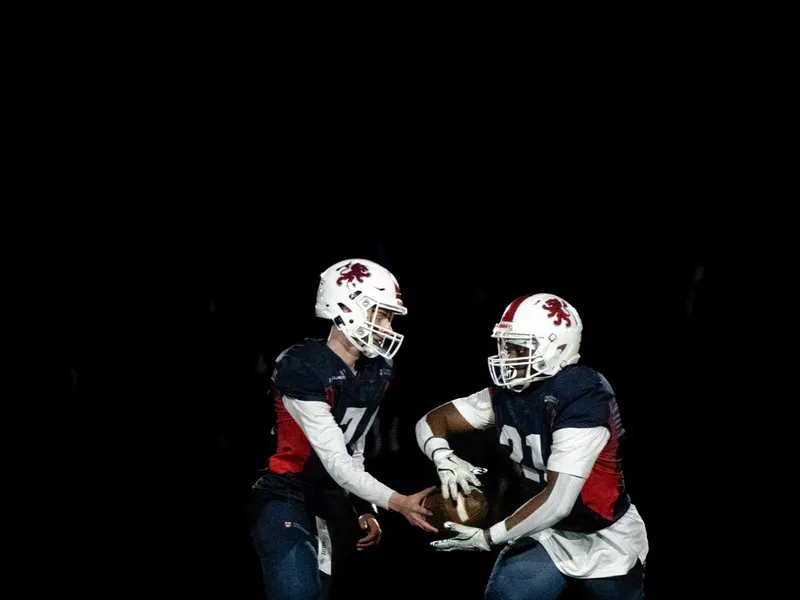 Two helmeted players facing each other on the turf