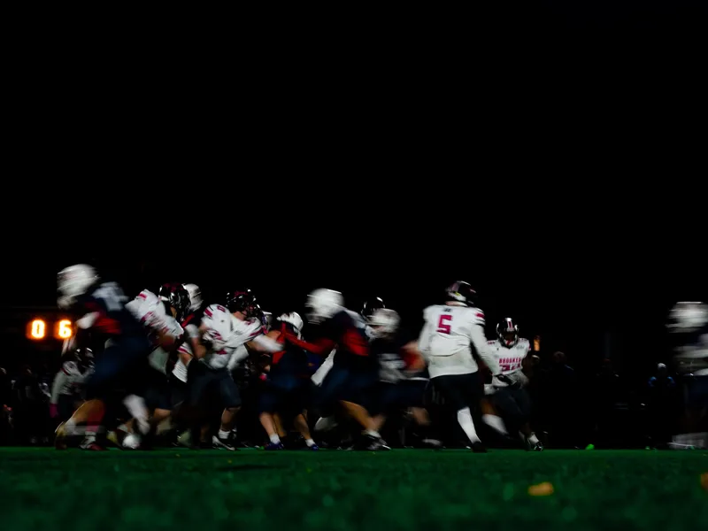 A team lined up across the field under floodlights at night