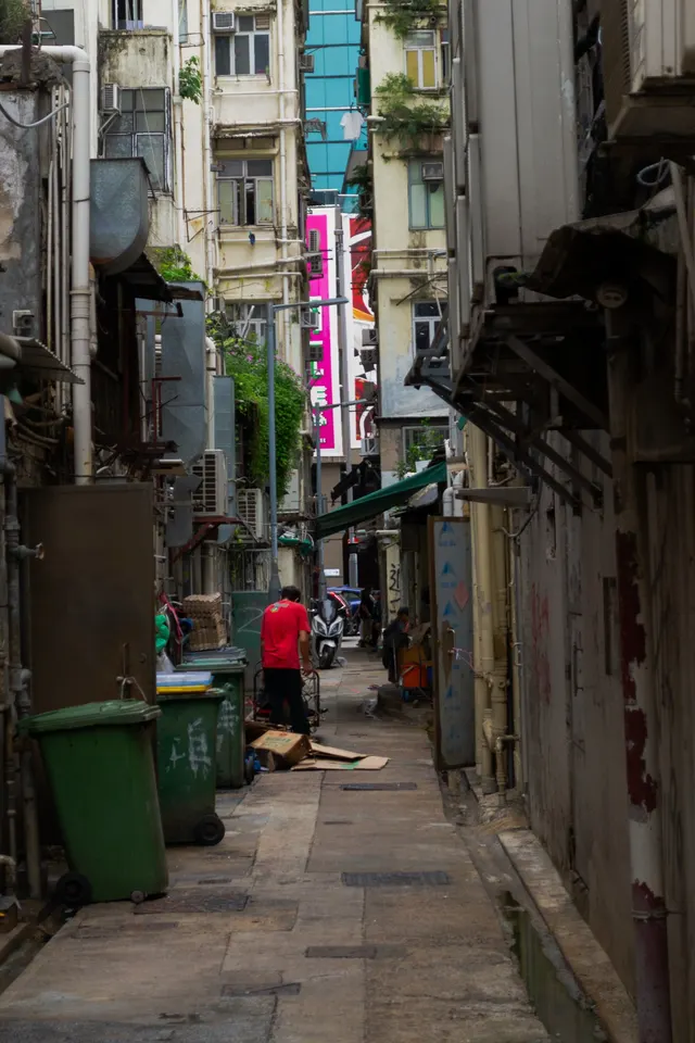 A narrow Hong Kong side street framed by shop signage and scaffolding