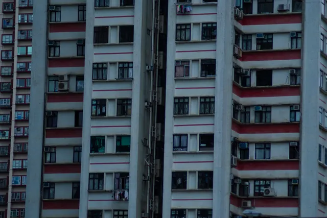 A red and white apartment facade, balconies repeating across the frame