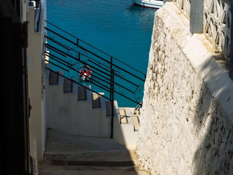 Stone steps dropping toward a harbour of moored white boats
