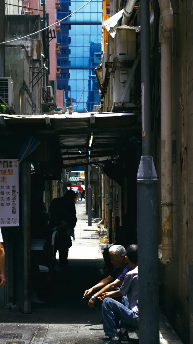 A Hong Kong back alley stacked with blue crates, laundry strung overhead