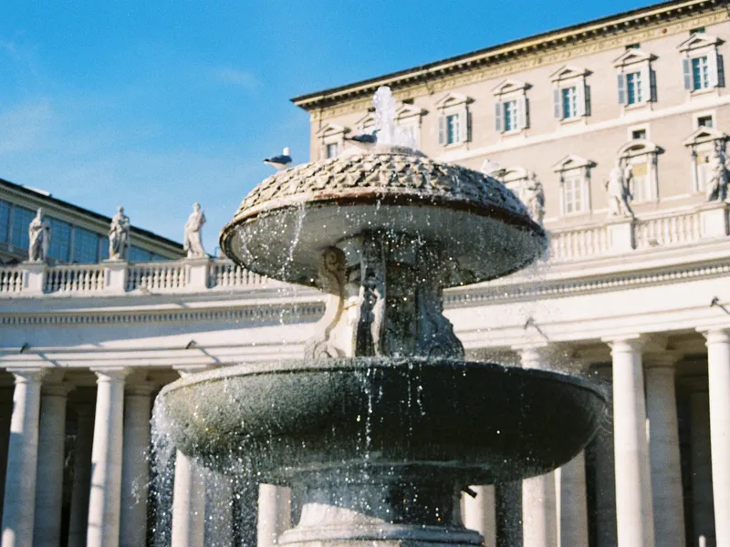 The tiered stone fountain in St Peter's Square with the colonnade behind it